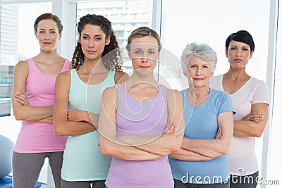 Confident women with arms crossed in yoga class