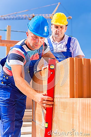 Construction site workers checking building shell