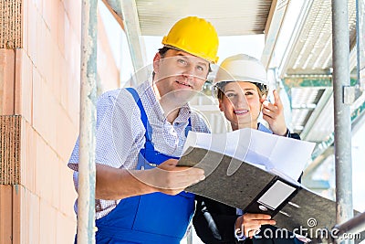 Construction Team with building plans on site