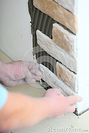 Construction worker installing tiles on a wall