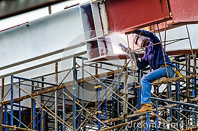 A Construction Worker welding steel bars.