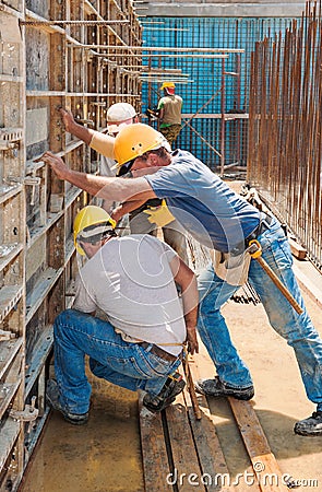 Construction workers busy with formwork frames