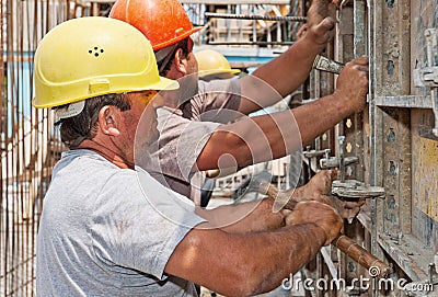 Construction workers positioning formwork frames