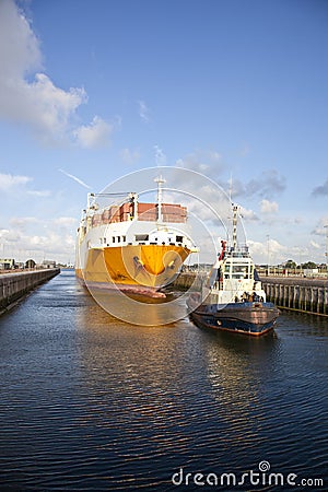 Container ship with tug boat in lock