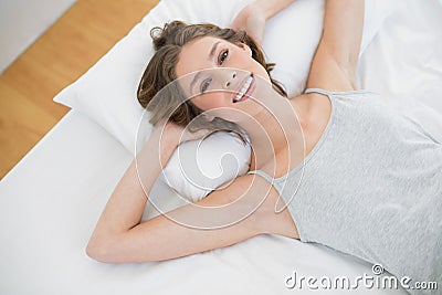 Content calm woman lying on her white bed in the bedroom