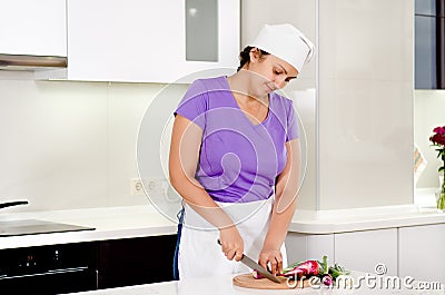 Cook chopping fresh vegetables in the kitchen