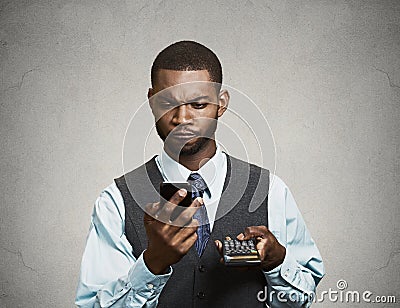 Corporate executive holding mobile phone and calculator