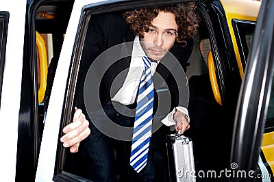 Corporate guy getting out of a taxi cab