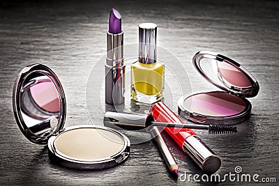 Cosmetics on black slate background