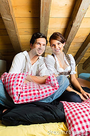 Couple with bed clothes in mountain cabin