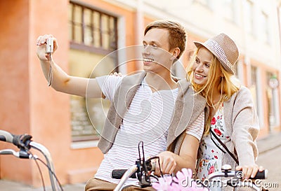 Couple with bicycles taking photo with camera