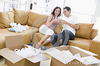 Couple with champagne by boxes in new home