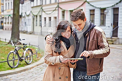 Couple in city with tablet computer