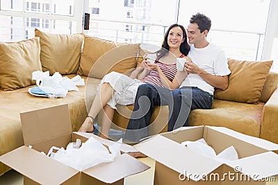 Couple with coffee by boxes in new home