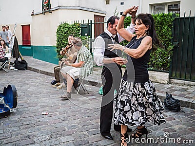 Couple dances to street musicians jazz on Montmartre in Paris