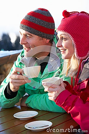 Couple Enjoying Hot Drink In Cafe At Ski Resort