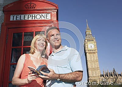 Couple With Guidebook Against London Phone Booth And Big Ben Tow