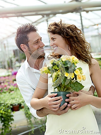 Couple have fun choosing flower pots in a greenhouse