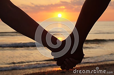 Couple holding hands at sunset