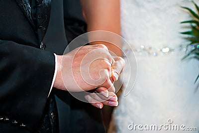 Couple holding hands at wedding ceremony