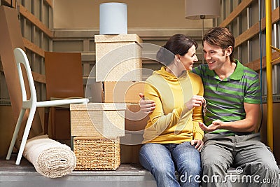 Couple Holding Key While Sitting Back Of Moving Van