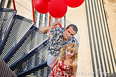 Couple holding red balloons