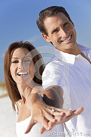 Couple Laughing Holding Hands on A Beach