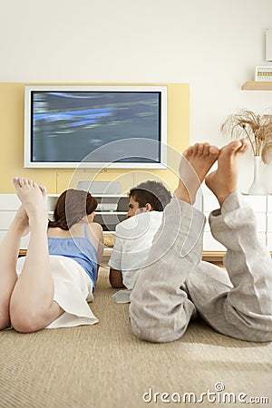 Couple Laying Down on Floor Watching TV