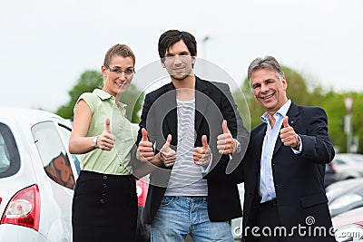 Couple looking at car on yard of dealer