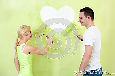 Couple painting heart on wall