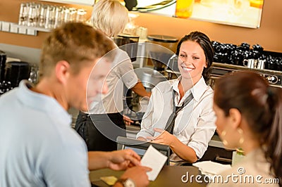 Couple paying bill at cafe cash desk