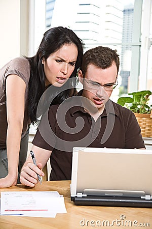 Couple paying bills by online banking