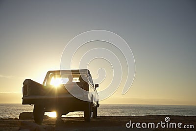 Couple In Pick-Up Truck Enjoying Sunset