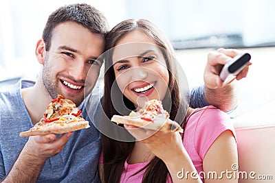 Couple with pizza and TV remote