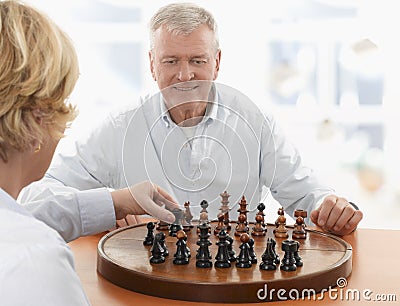 Couple playing chess in living room
