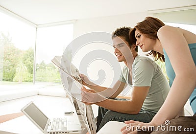 Couple Reading Newspaper at Home