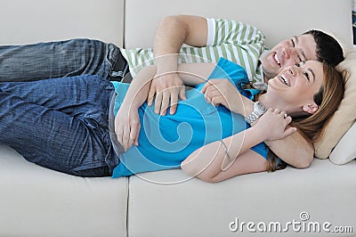 Couple relax at home on sofa in living room