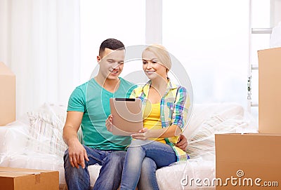 Couple relaxing on sofa with tablet pc in new home