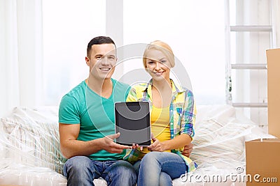 Couple relaxing on sofa with tablet pc in new home