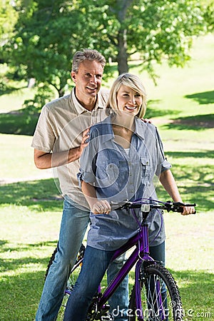 Couple riding bicycle in park