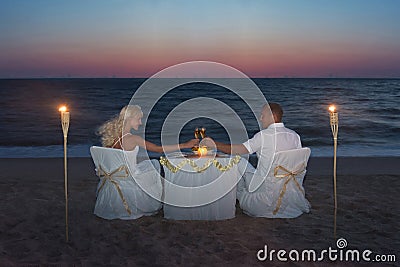 Couple at sea beach during luxury romantic dinner, with candles