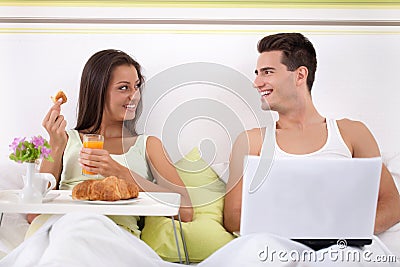 Couple sitting on bed in morning