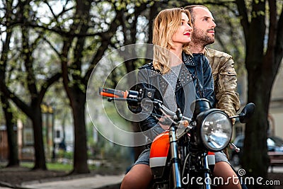 Couple sitting on the motorcycle in the city park