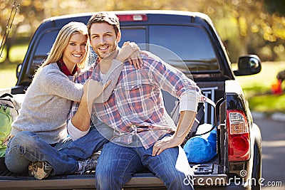 Couple Sitting In Pick Up Truck On Camping Holiday