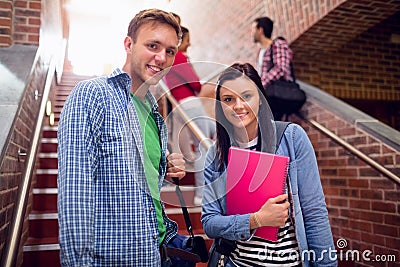 Couple with students behind on stairs in college