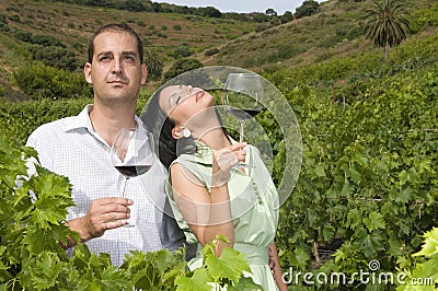 Couple tasting wine in a vineyard