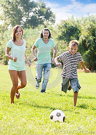 Couple and teenager boy playing with soccer ball