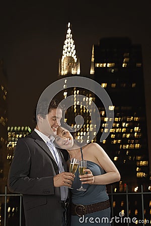 Couple Toasting Champagne Against New York Skyline