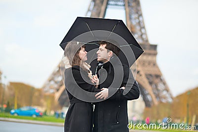 Couple with umbrella near Eiffel tower