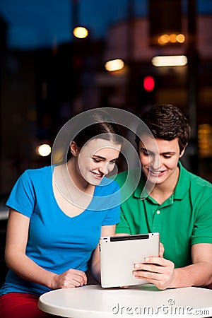 Couple using digital tablet in cafe